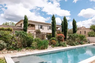 a villa with a swimming pool in front of a house at Le Mas de Cink in Saint-Saturnin-les-Apt