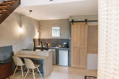 a kitchen with a counter and some chairs in it at Le Mas de Cink in Saint-Saturnin-les-Apt