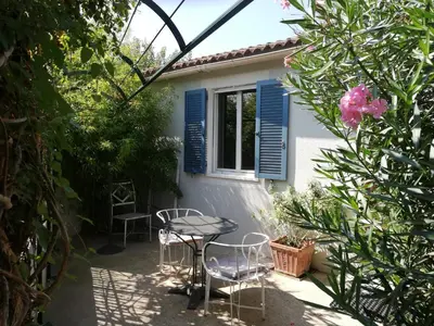 a patio with a table and chairs in front of a house at Gîte de la treille in LʼIsle-sur-la-Sorgue
