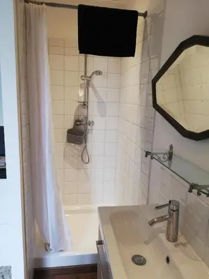 a bathroom with a tub and a sink and a mirror at Gîte de la treille in LʼIsle-sur-la-Sorgue