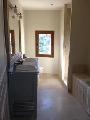 a bathroom with a sink and a toilet and a window at Ancienne Maison des Gardes in Lourmarin