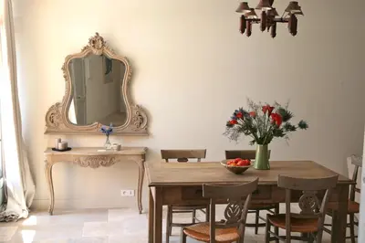 a dining room with a table and a mirror at Ancienne Maison des Gardes in Lourmarin