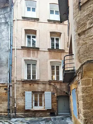 an old brick building with white doors and windows at Le Mirabeau studio au cœur du centre historique - 2eme étage in Aix-en-Provence