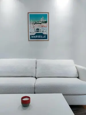 a living room with a white couch and a picture on the wall at Le Mirabeau studio au cœur du centre historique - 2eme étage in Aix-en-Provence