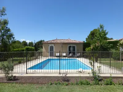 a fence around a swimming pool in a yard at Charming Holiday Villa with Pool in LʼIsle-sur-la-Sorgue