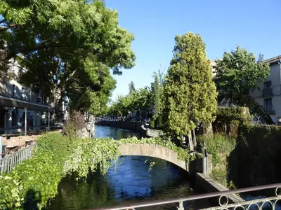 a bridge over a river in a city at Charming Holiday Villa with Pool in LʼIsle-sur-la-Sorgue