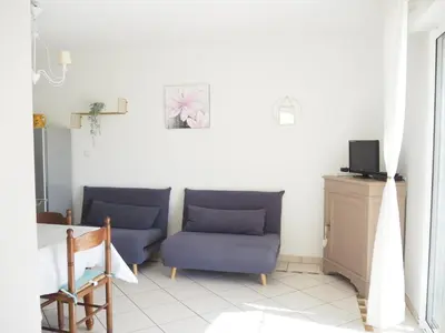 a living room with two blue chairs and a tv at Charming Holiday Villa with Pool in LʼIsle-sur-la-Sorgue