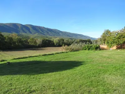 a large grass field with a large shadow on it at Domaine de la Bastidonne in Céreste