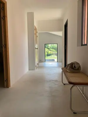 an empty white room with a chair and a hallway at Le Jardin des Graminées in Cabrières-dʼAvignon