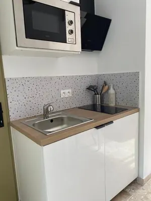 a small kitchen with a table and a chair at Le studio de Marie in Noves