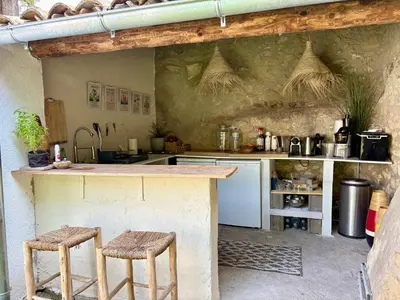 a kitchen with a counter and two stools at Quiet Provencal bastide with pool close Lourmarin in Lauris