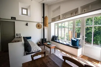 a living room with a table and some windows at Le Poulailler, private house with garden and parking in Aix-en-Provence