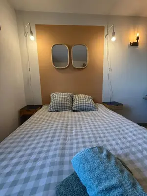 a bedroom with a bed with two mirrors on the wall at Le Clos D'AIX Studio 108 in Aix-en-Provence