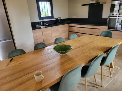 a kitchen with a wooden table and chairs at La Bastide des Amis in Caromb