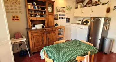 a kitchen with a table and a refrigerator at Spacious apartment 4 people parking, bright in Aix-en-Provence