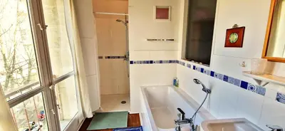 a bathroom with a tub and a sink and a window at Spacious apartment 4 people parking, bright in Aix-en-Provence