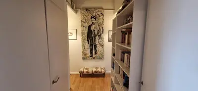 a hallway with bookshelves and a painting on the wall at Spacious apartment 4 people parking, bright in Aix-en-Provence