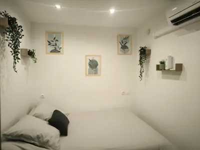 a white room with a bed and some plants at studio in Morières-lès-Avignon