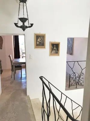 a stairway with a chandelier and paintings on the wall at Roussillon House in Roussillon