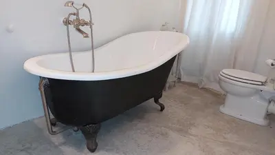 a black and white bath tub in a bathroom with a toilet at Roussillon House in Roussillon