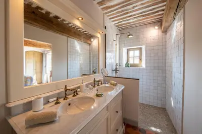 a bathroom with two sinks and a large mirror at La Bastide in Oppède