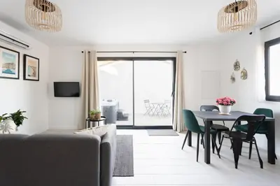 a living room with a table and green chairs at La maison d'Alice - Calme - Climatisation - Parking privatif in Velaux