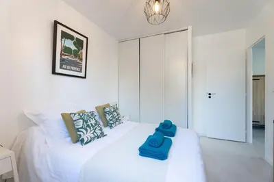 a bedroom with a white bed with blue towels on it at La maison d'Alice - Calme - Climatisation - Parking privatif in Velaux