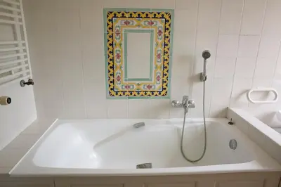 a bathroom with a bath tub with a mirror at Le mas provençal d'Aurélie in Carpentras