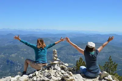 two women sitting on top of a mountain holding their hands up at L'Orée du Ventoux - Crillon-le-Brave in Crillon-le-Brave