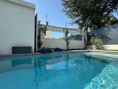 a swimming pool in front of a white wall at Chambres d'hôte in Châteauneuf-de-Gadagne