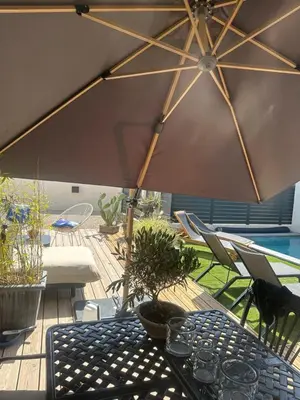 a patio with a table and an umbrella at Chambres d'hôte in Châteauneuf-de-Gadagne