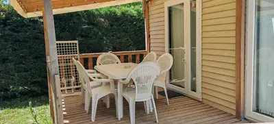 a patio with a table and chairs on a deck at Mobilhome 6 personnes in Cheval-Blanc