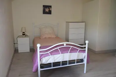a small bedroom with a bed with purple and white sheets at Gite chez les Truph in Entraigues-sur-la-Sorgue