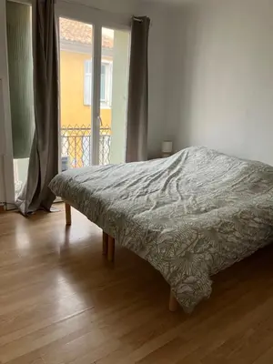 a bed in a bedroom with a wooden floor at Maison de village à Pertuis in Pertuis
