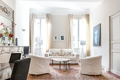 a living room with a couch and a table and chairs at Bel appartement près du Cours Mirabeau in Aix-en-Provence