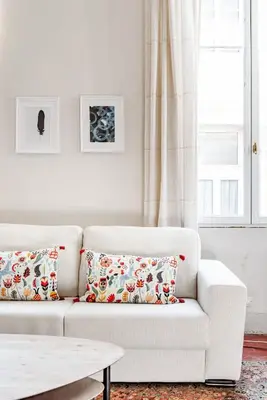 a white living room with a white couch with pillows at Bel appartement près du Cours Mirabeau in Aix-en-Provence