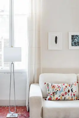a white living room with a couch and a lamp at Bel appartement près du Cours Mirabeau in Aix-en-Provence