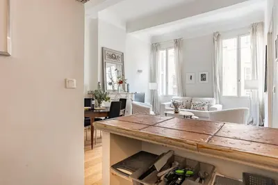 a kitchen and living room with a wooden counter top at Bel appartement près du Cours Mirabeau in Aix-en-Provence