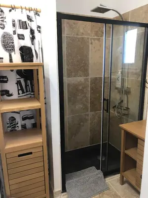 a shower with a glass door in a bathroom at Maison de charme in Monteux