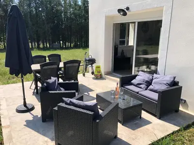 a patio with chairs and a table and an umbrella at Maison de charme in Monteux