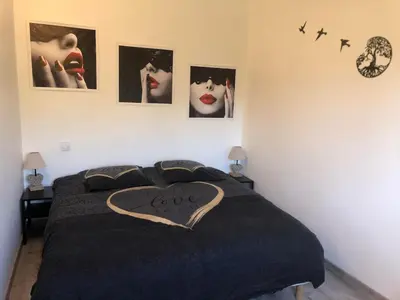 a bed with a black blanket with a heart on it at Maison de charme in Monteux