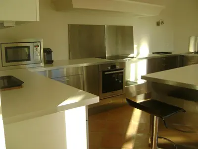 a kitchen with stainless steel appliances and a counter at Bastide des Lauves in Aix-en-Provence