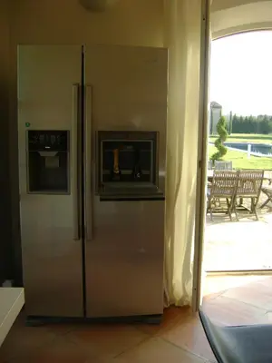 a stainless steel refrigerator with a fireplace in a room at Bastide des Lauves in Aix-en-Provence