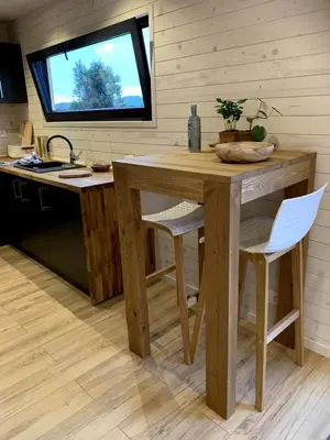 a wooden table and chairs in a kitchen with a window at Lodge en Provence in Mouriès