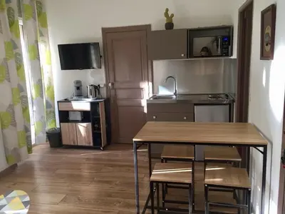 a kitchen with a table and chairs in a room at Appartement T2 Centre in Carpentras