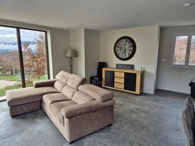 a living room with a couch and a clock on the wall at Lou damisello - Villa moderne in Viens