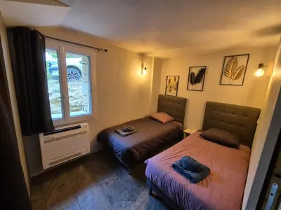 a bedroom with two beds and a window at Lou damisello - Villa moderne in Viens