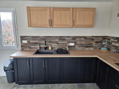 a kitchen with black cabinets and a sink at Lou damisello - Villa moderne in Viens