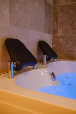 a sink with two black faucets on top of it at AMA, suite avec baignoire balnéo et sauna privé in Avignon