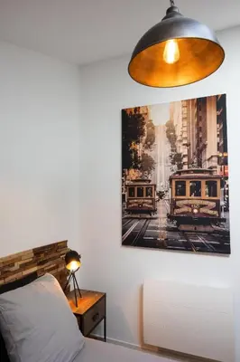 a bedroom with a painting on the wall next to a bed at Duplex Factory II Hyper Centre in Salon-de-Provence